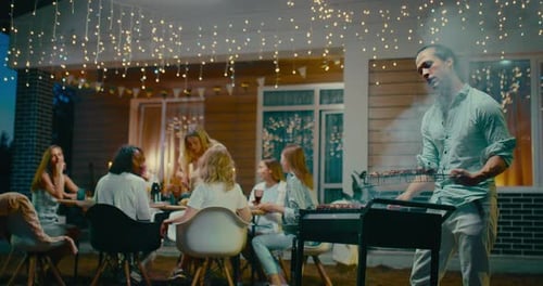 Friends Enjoying Backyard Barbecue Party at Night