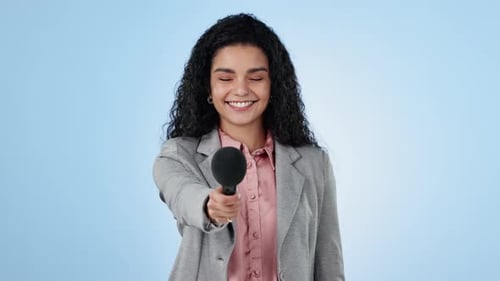 Face, microphone and media with a woman reporter on a blue background in studio for an interview