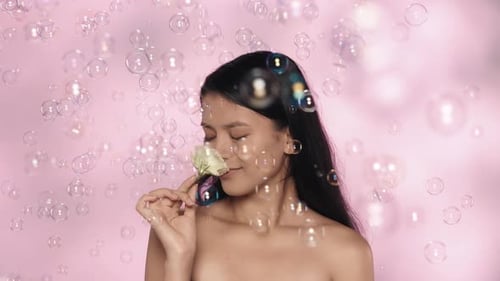 Closeup Studio Shot of Beautiful Female Model Brunette Girl Holding Rose Flower and Smiling at the