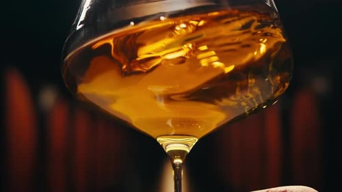 Orange or White Wine Bottle and Glass Against a Sunset in a Peaceful Vineyard Pouring of Ecological