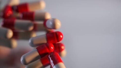 Haufen medizinischer Kapseln, Pillen, die auf den grauen Spiegeltisch fallen, Nahaufnahme, Antibiotika, Vitamine