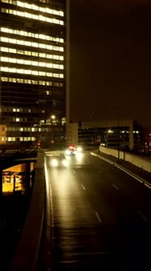 A Captivating Urban Night Scene Showcases Illuminated Buildings Alongside a Bustling Highway