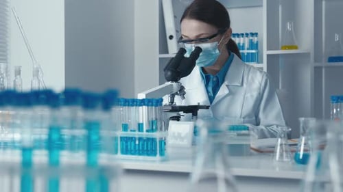 Female Scientist Using Microscope in Modern Laboratory