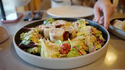 Woman presenting a salad at a restaurant