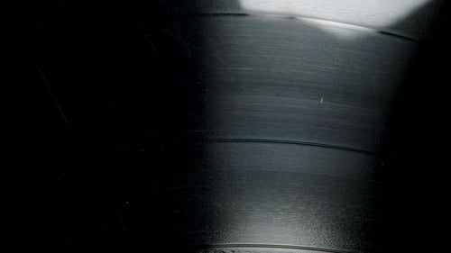 The surface of the vinyl record, with the sound track groove forming a spiral. Dolly slider.