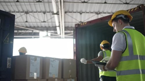 Blue collar workers are working at warehouse.