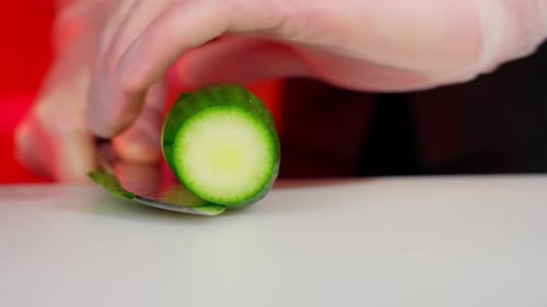 Closeup of Cutting Fresh Cucumber with a Knife Cooking Concept