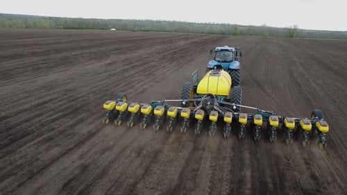 Blue tractor OA working on the field in Ukraine