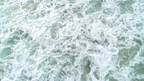 Top Down Aerial View of Giant Ocean Waves Crashing and Foaming