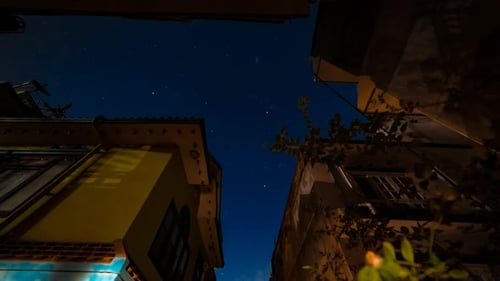 Night Sky timelapse with buildings in the foreground.