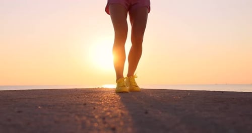 Fit woman jumping rope at the beach during summer vacation. Slow motion