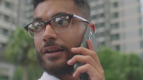 Young adult with glasses talking on the phone