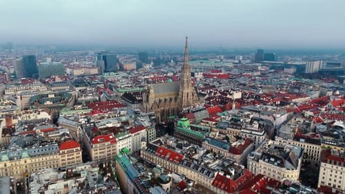 wide angle landscape drone shot panning right of st Stephens cathedral in Vienna with winter clouds