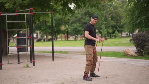 Individual Readies Resistance Band In Open Gym Environment Person Organizes Fitness Equipment At