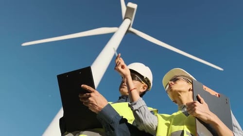 Low Angle View of Two Maintenance Engineers Working Together in the Wind Farm
