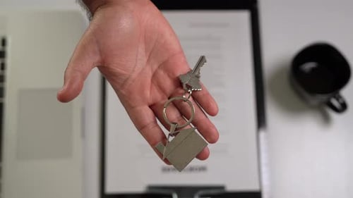 Hispanic Male Hand Handing Over House Keys. Realtor Real Estate Agent Selling Property. Close Up