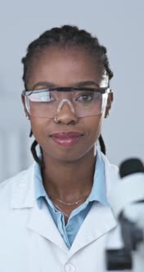 Scientist Smiles in Lab with Microscope