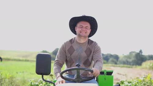 Farmer on a Mini Tractor Driving on the Field Cultivation of Vineyard Plantations