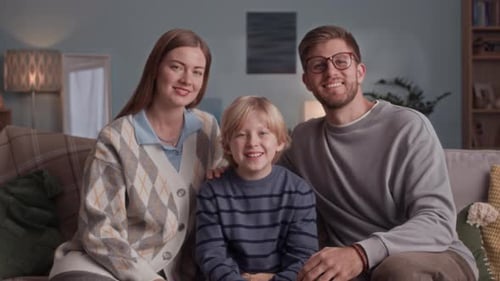 Smiling Family Posing Together on Couch