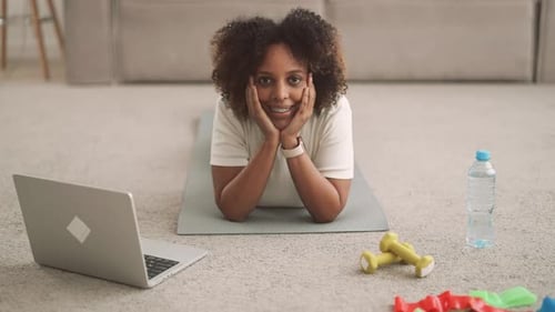 Woman Lying on Exercise Mat Smiling at Camera