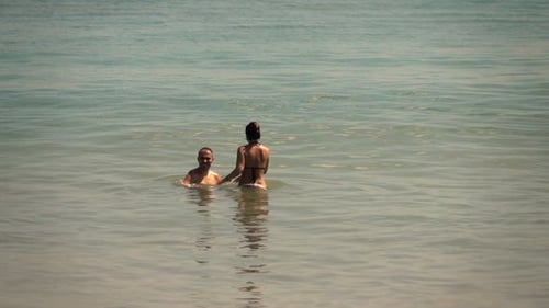 Young couple's carefree summer bliss relaxing together in super slow motion at sea