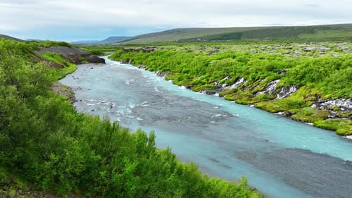 River with Clear Glacial Water Mountain Waterfall Surrounded By Dense Green Trees and Bushes