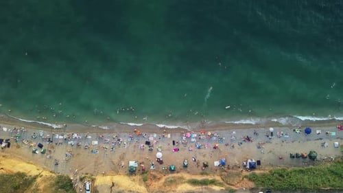 Aerial View of Sandy Beach Swimming People in Sea Bay with Transparent Blue Water at Sunset in