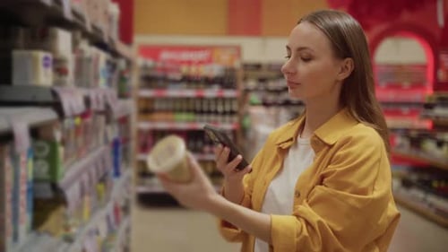 Woman Shopping Groceries With Smartphone In Supermarket