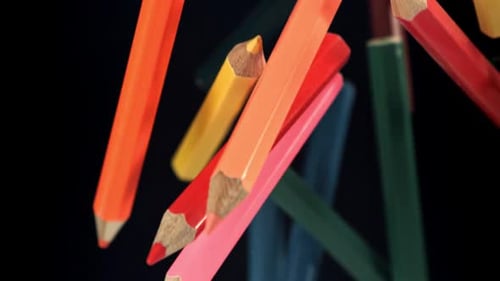 Multicolored Pencils Fly and Fall on a Black Background Filmed on a Highspeed Camera at 1000 Fps