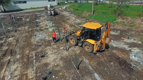 Backhoe and Workers at Construction Site
