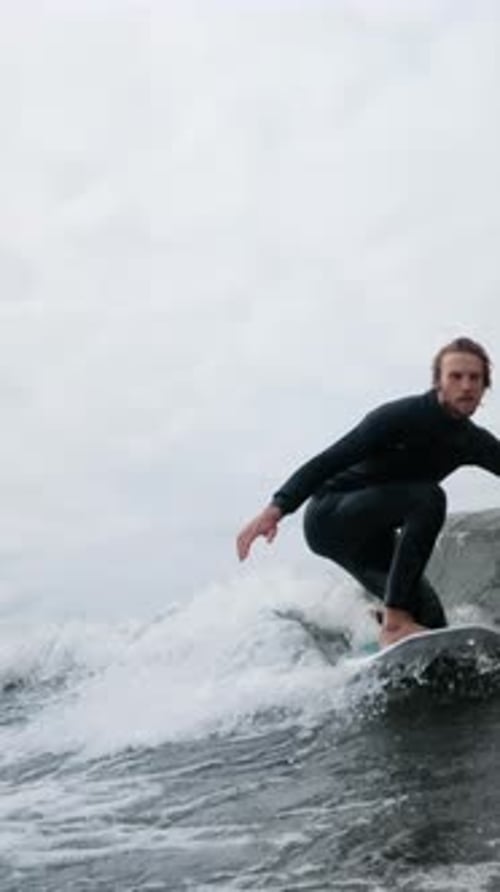 A Surfer Riding a Wave with Style and Precision Capturing the Thrilling Essence of Water Sports