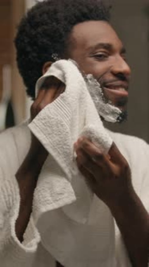 Man Dries Face with Towel After Shaving
