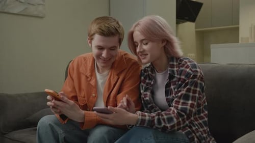 Couple Relaxing on Couch Looking at Phones Together