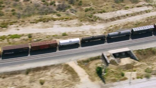 Aerial View of Train Cars Moving Along Tracks