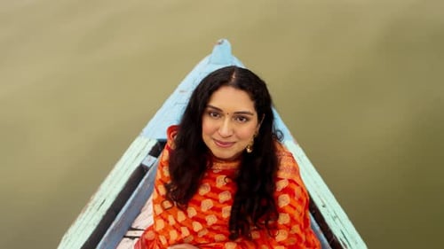 Over Head View of Indian Woman Sitting in Boat and Looking in the Camera