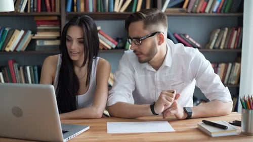 Students brainstorm ideas discussing work project in trendy loft library closeup