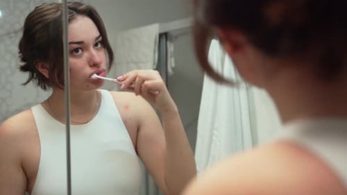 Adolescente cepillándose los dientes en el baño en casa: concepto de cuidado dental, higiene y estilo de vida saludable