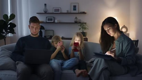 Family Relaxing on Couch with Technology at Home