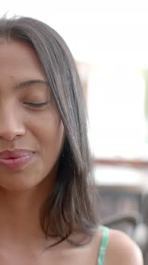 Vidéo verticale : Une jeune femme caucasienne sourit chaleureusement, les yeux brillants