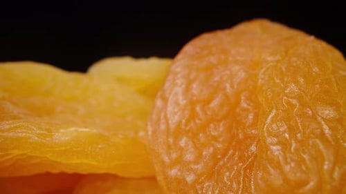Dried apricots or dried apricots on a black background, Dolly slider extreme close-up.