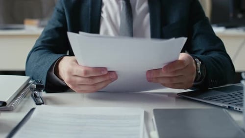 Man Typing and Stapling Papers at Office Desk