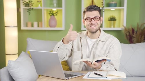 Man Reads Book and Gives Thumbs Up Indoors