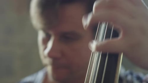 Close Up of Man Playing Stringed Instrument