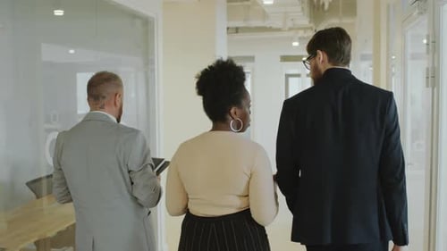 Geschäftspartner gehen durchs Büro und besprechen die Arbeit