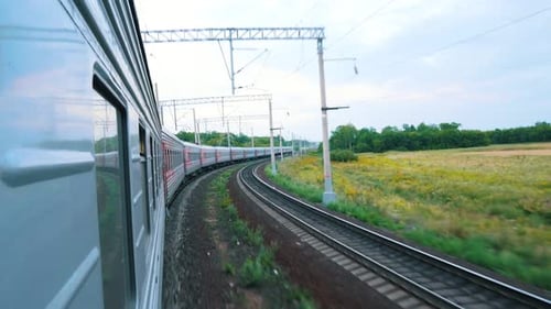 Train Travels Through Rural Landscape on Railroad Tracks
