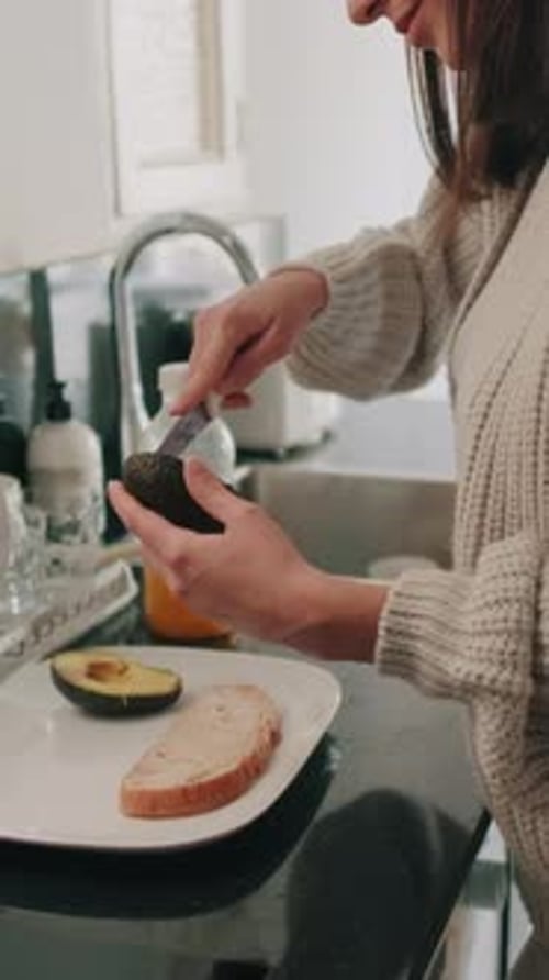 Woman Prepares Avocado Toast in Bright Kitchen