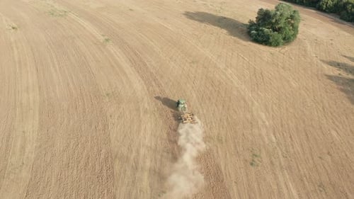 Agricultural Tractor Plowing Farm Land - Descending Aerial Tilt-Up Reveal