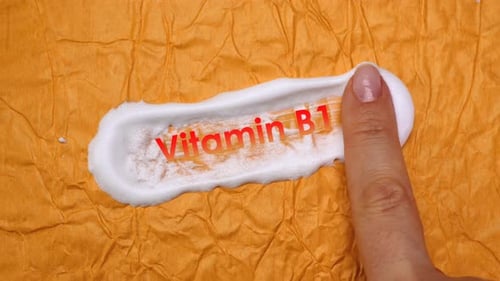 Finger applying a smear of cream vitamin B1 animation or smears cream on a yellow background