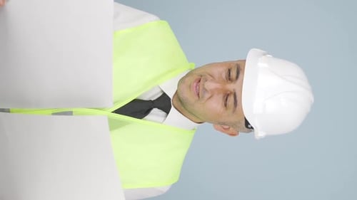 Vertical video of The engineer examines the project in his hands.