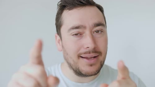 Young Man Pointing at Camera with Playful Expression